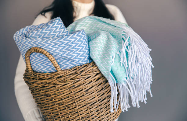 Woman folding clean laundry with sustainable products in laundry room